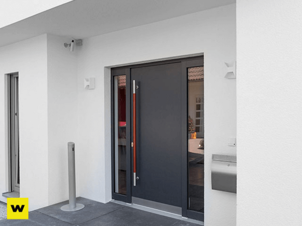 Moderne Haustür aus Aluminium mit Seitenteil und Edelstahlgriff in weißer Fassade.